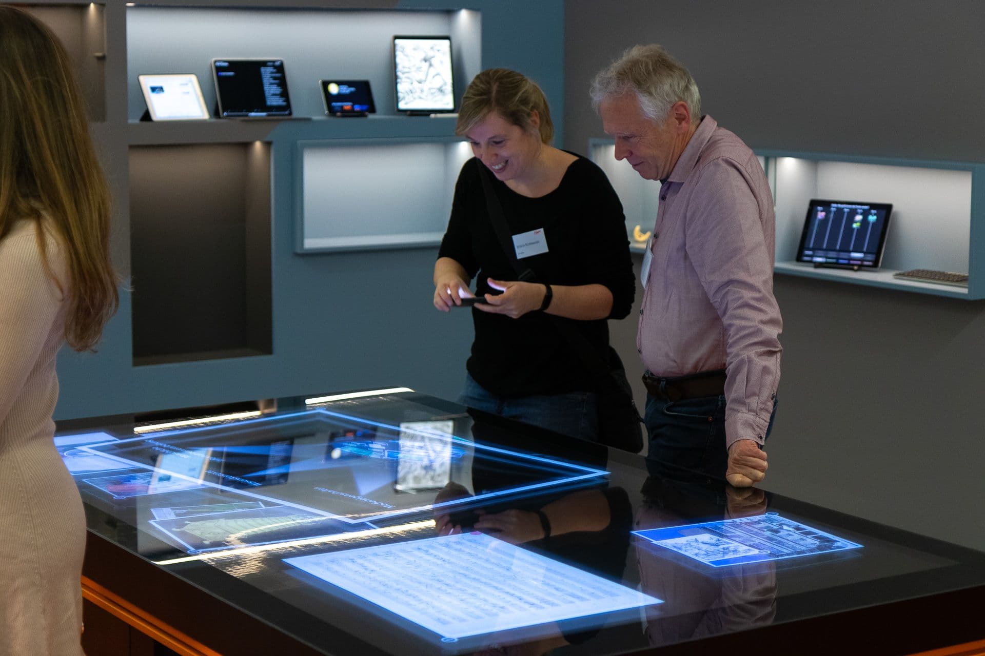 Two IWM alumni in front of a multi-touch table