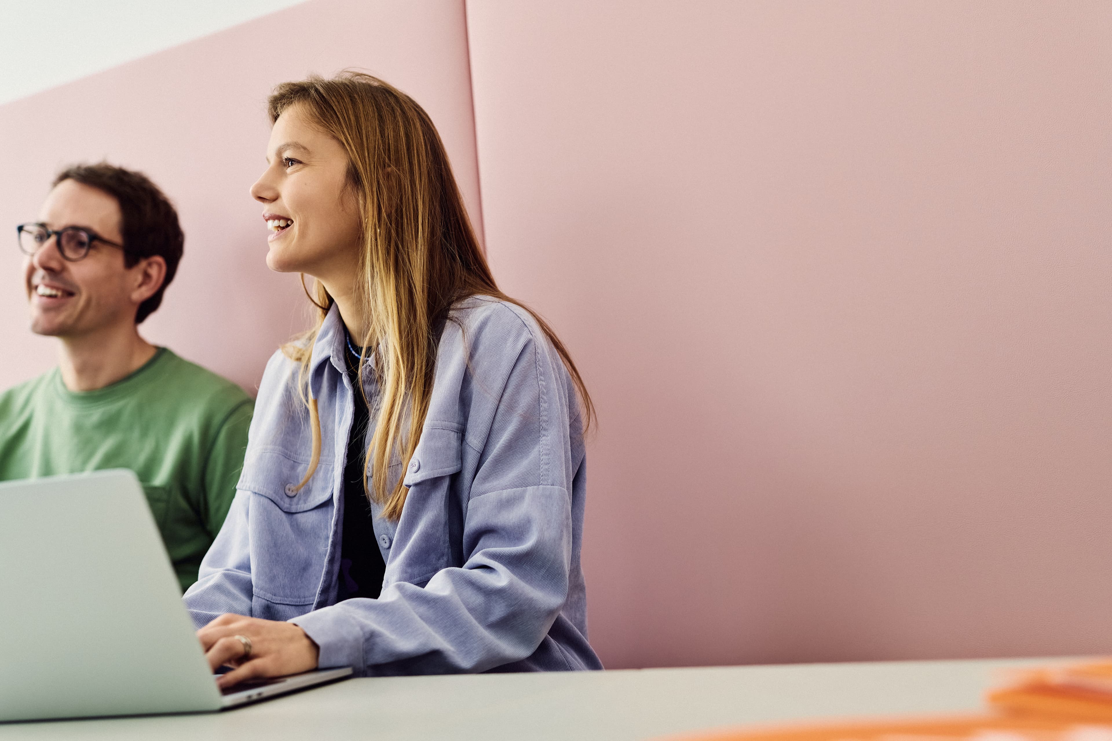 Two IWM employees with a laptop sitting in the work café
