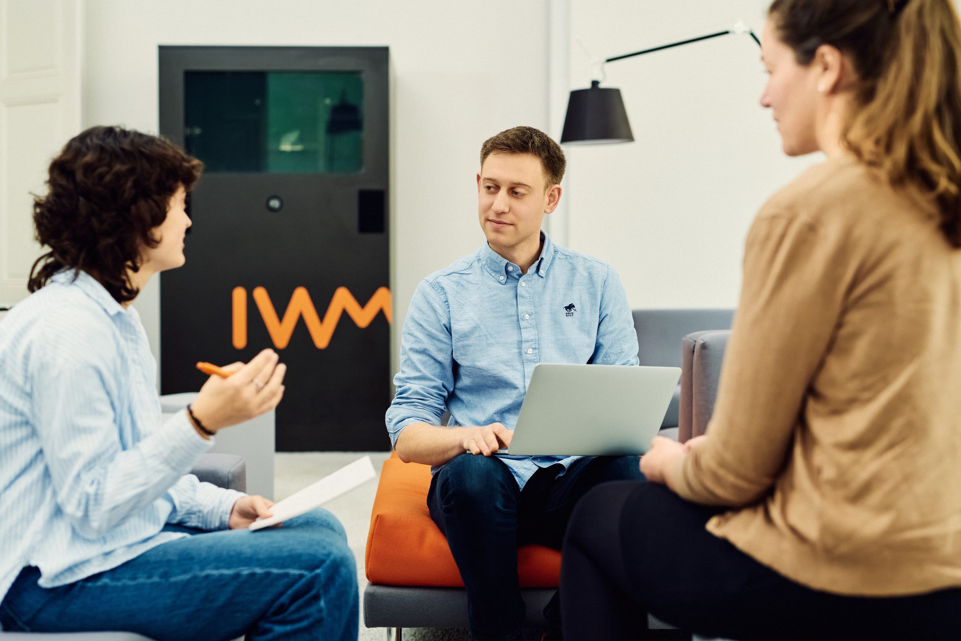 Drei IWM-Mitarbeitende sitzen zusammen und unterhalten sich