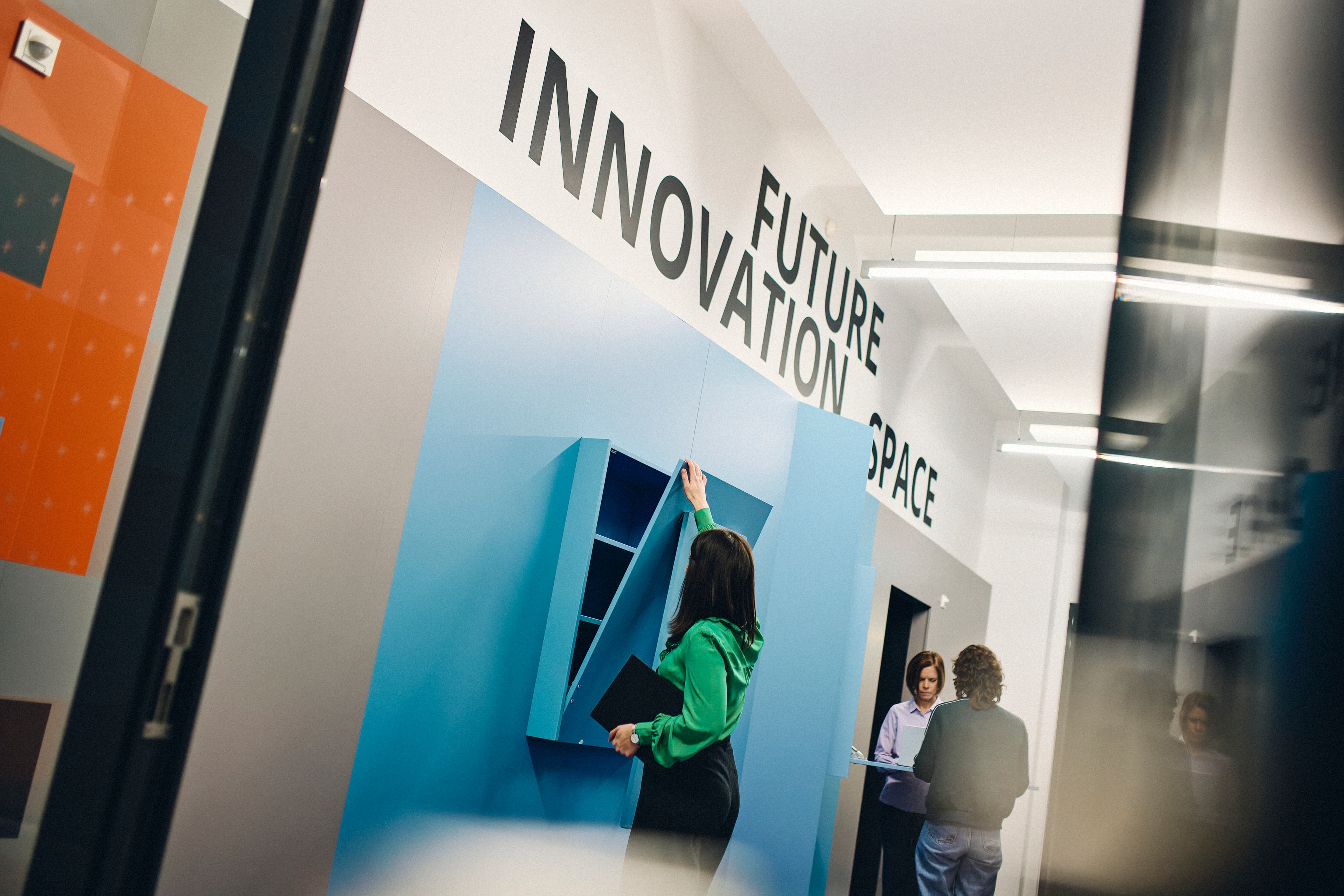 Three people working in front of the Future Innovation Space