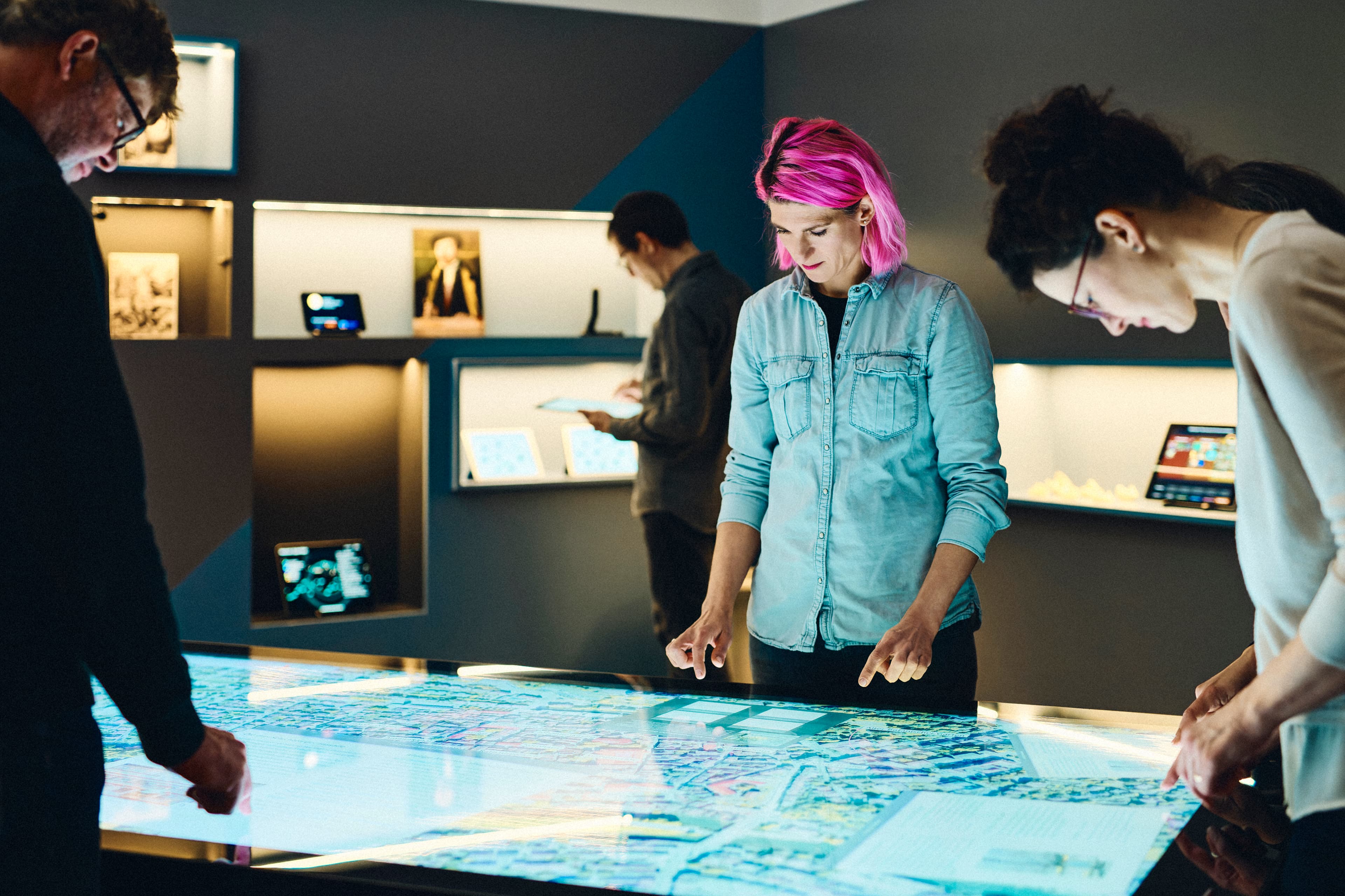 Several people working together at a multi-touch table in the IWM